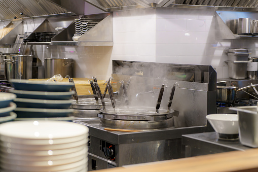 Bustling kitchen of a ramen restaurant steaming broth to skillfully crafted noodles, this scene embodies the culinary mastery and dedication to authentic flavors