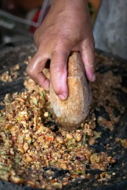 Photo of people make ingredients for traditional Rujak seasoning from peanuts, soy sauce, chili peppers and petis in close up