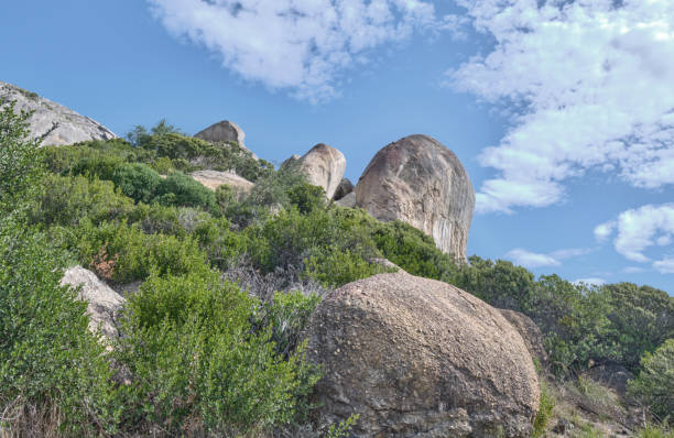 boulders and wilderness - and blue sky with clouds - straggling стоковые фото и изображения