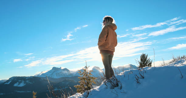 istock Young woman explores snowy hillside 1910804055