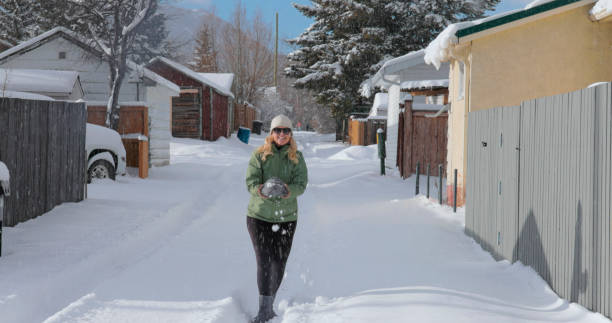 mujer madura lanza bola de nieve - people personal accessory town hat fotografías e imágenes de stock