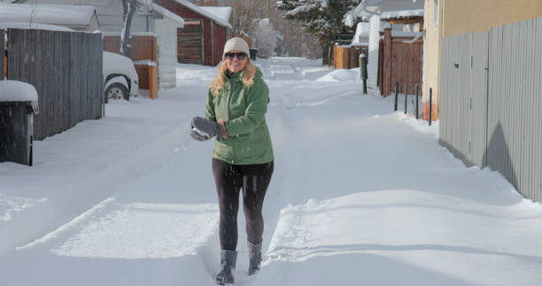 mujer madura lanza bola de nieve - people personal accessory town hat fotografías e imágenes de stock