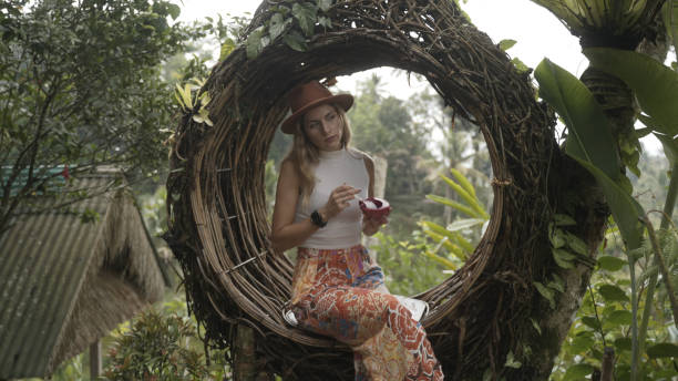 istock Young woman sits in circular chair 1910810273