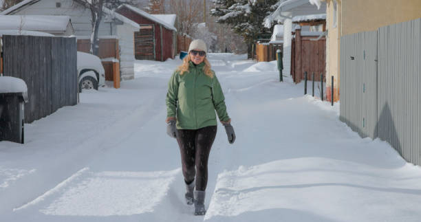 mujer madura lanza bola de nieve - people personal accessory town hat fotografías e imágenes de stock