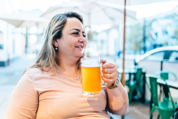 istock Woman drinking beer at sidewalk bar 1910813319