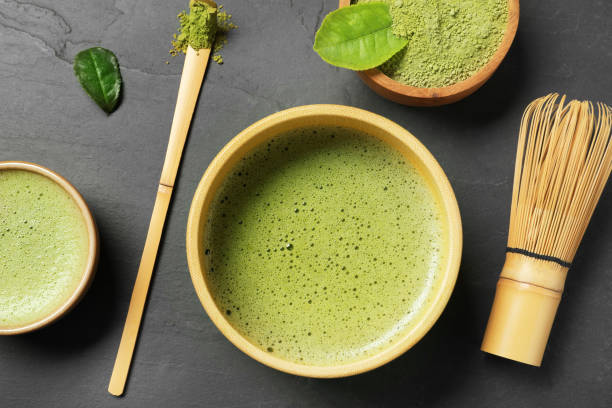 istock Fresh matcha tea, bamboo whisk, spoon and green powder on black table, flat lay 1910833663