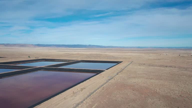 Drone Shot of a Oilfield Water Retention Ponds in Eastern Utah Near Thompson Springs on a Sunny Winter Day with The Dramatic Sky Reflecting in the Water