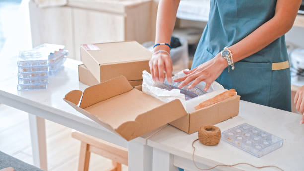 istock Close up of hand packing orders into box 1910843024