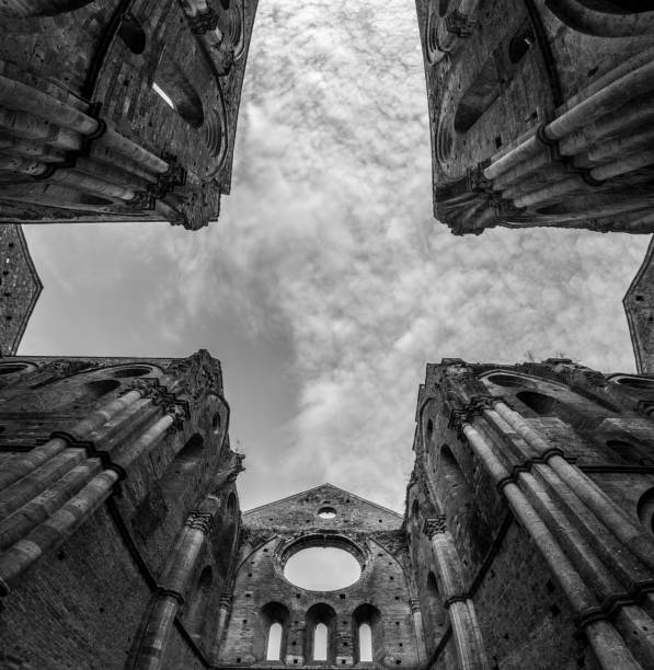 missing ceiling opening the view to the sky in the destroyed abandoned cistercian monastery san galgano in the tuscany - italy old ruin abbey basilica imagens e fotografias de stock