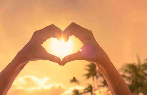 istock Woman making heart against a beautiful sunset. 1910855882