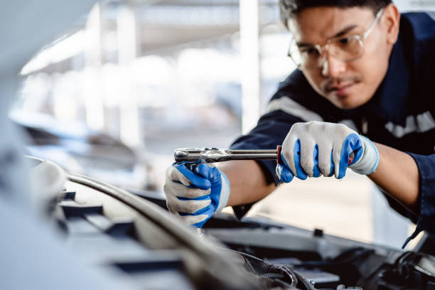 Auto mechanic repairman using a socket wrench working engine repair in the garage, changing spare parts, checking the mileage of the car, maintaining service automobile car