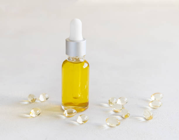 istock Oil in a bottle and capsules on a white table close up 1910915337