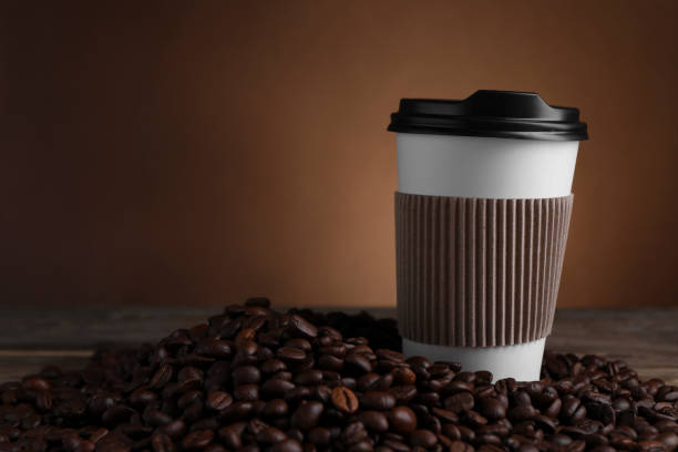 istock Coffee to go. Paper cup and roasted beans on table, space for text 1910915893