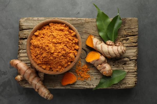 istock Aromatic turmeric powder and raw roots on grey table, top view 1910938934