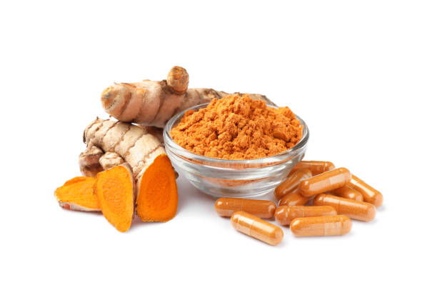 istock Bowl with aromatic turmeric powder, pills and cut roots isolated on white 1910940063