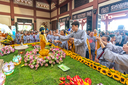 Ho Chi Minh City, Vietnam - May 19th, 2019: Group of Vietnamese Buddhist bath Buddha statue purify body and spirit in Buddha birthday celebration at pagoda in Ho Chi Minh City, Vietnam