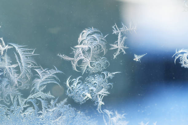 frost crystal on window glass in winter season - frosted glass glass textured crystal stock-fotos und bilder