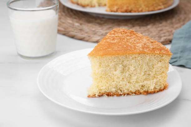istock Plate with piece of tasty sponge cake on white marble table 1910965732