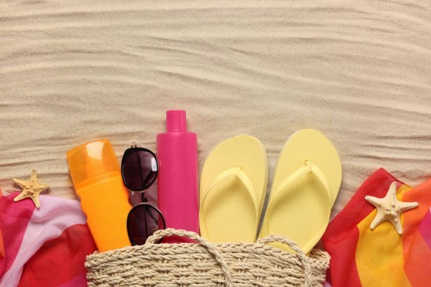 istock Flat lay composition with wicker bag and other beach accessories on sand. Space for text 1911022731