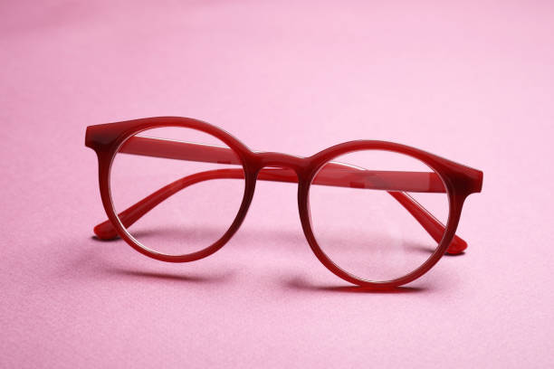 istock Stylish pair of glasses with red frame on pink background 1911033167