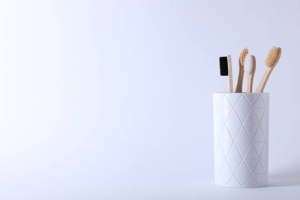 istock Bamboo toothbrushes in holder on white background, space for text 1911034207