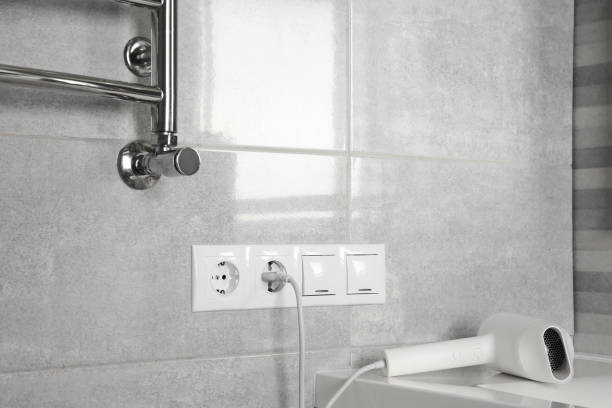istock Hairdryer plugged into power socket on light grey wall 1911044182