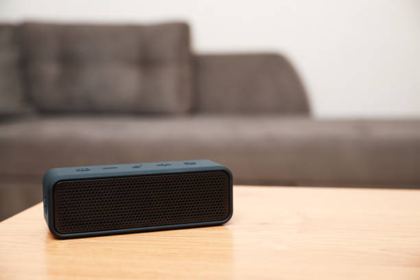 istock One black portable bluetooth speaker on wooden table indoors, space for text. Audio equipment 1911046353