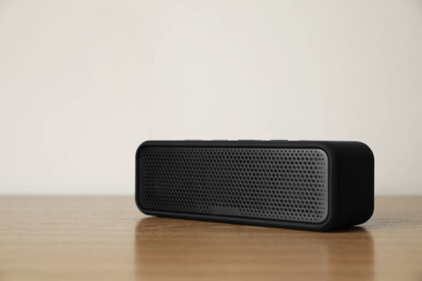 istock One black portable bluetooth speaker on wooden table. Audio equipment 1911046871