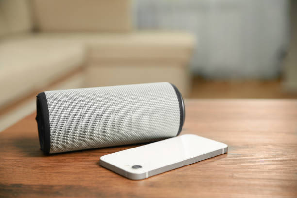 istock Portable bluetooth speaker and smartphone on wooden table indoors, space for text. Audio equipment 1911046872