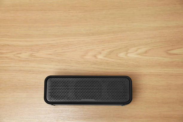 istock One portable bluetooth speaker on wooden table, top view with space for text. Audio equipment 1911046889
