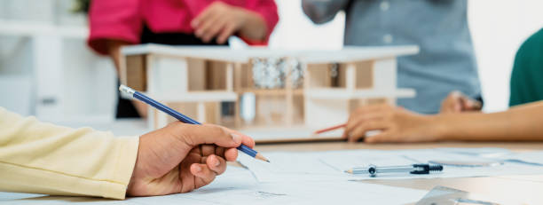 istock Professional architect team discussing about house design. Closeup. Variegated. 1911101278