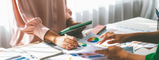 istock Skilled architect holds tablet while selects color from color wheel. Variegated. 1911138906