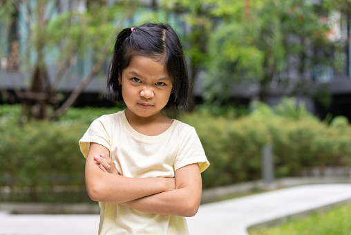 Portrait of an Asian angry and sad little girl. The emotion of a child when tantrum and mad, expression of grumpy emotion. Kid emotional control, attention deficit hyperactivity disorder concept ADHD