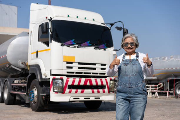 business owner standing in front of oil truck after performing a pre-trip inspection on a truck. concept of preventive maintenance. - truck fuel tanker semi truck milk tanker stock-fotos und bilder