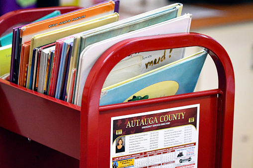 Prattville, Alabama, USA-Dec. 11, 2023: Close-up of a red cart filled with picture books in the children's library at the Autauga-Prattville Public Library.