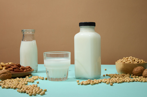 Blue surface featured a lot of soybeans and a dish containing some nuts. Soy drink is one of the easiest and most convenient choices