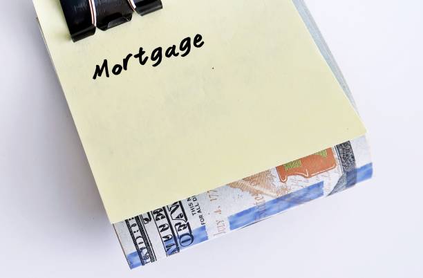 istock A yellow paper note clipping on dollars bank notes with handwritten text MORTGAGE, concept of saving or set budget for house loan or mortgage payment - on white background can used as copy space 1911264142