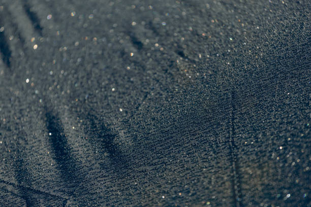 istock Drops of water on a dark matte surface close up. 1911301003