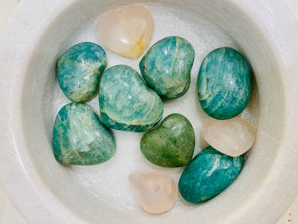 Horizontal flat lay of white stone bowl with small raw crystal healing energy stones of rose quartz, aquamarine, adventurine and more, in Byron Bay Australia