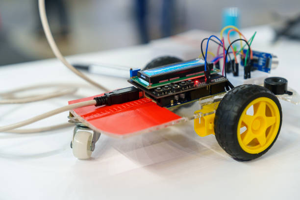 In a science project, a close-up view of a DIY robotic car on working desk background captures the essence of coding, technology, robotics, and science. This image represents the exciting intersection of these fields, showcasing innovation and the future of technology.