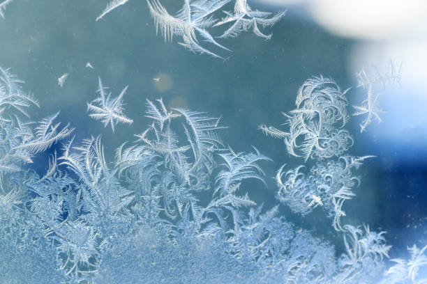 frost crystal on window glass in winter season - frosted glass glass textured crystal stock-fotos und bilder