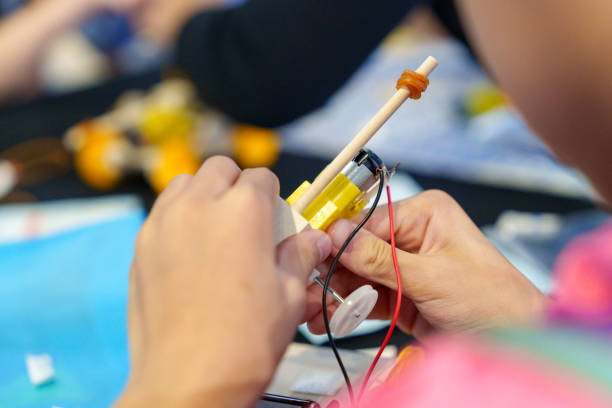 istock The close-up view showcases a student diligently working on a DIY robotic car, capturing the essence of coding, technology, robotics, and science. 1911389179