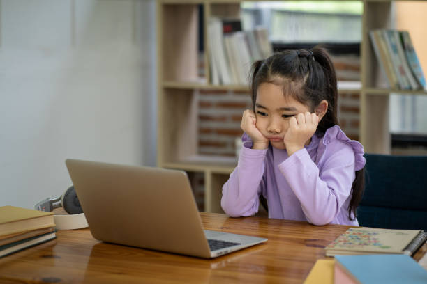 istock Young Asian girl doing homework online using laptop computer to improve her learning skills. 1911396889