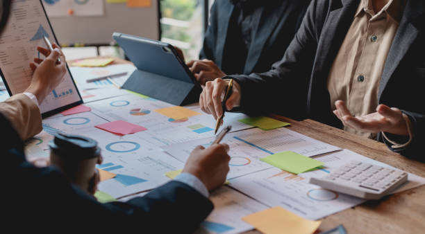 istock Group of businesspeople meeting and presenting, discussing and analyzing data, pointing to charts and graphs of finance and accounting, business ideas for future growth. 1911398467