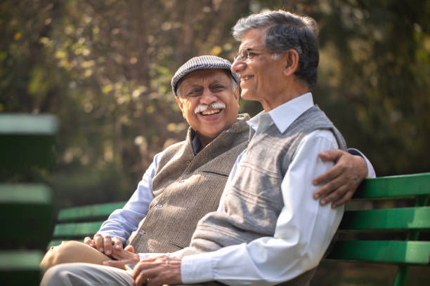istock Happy elderly friends resting on park bench 1911400088