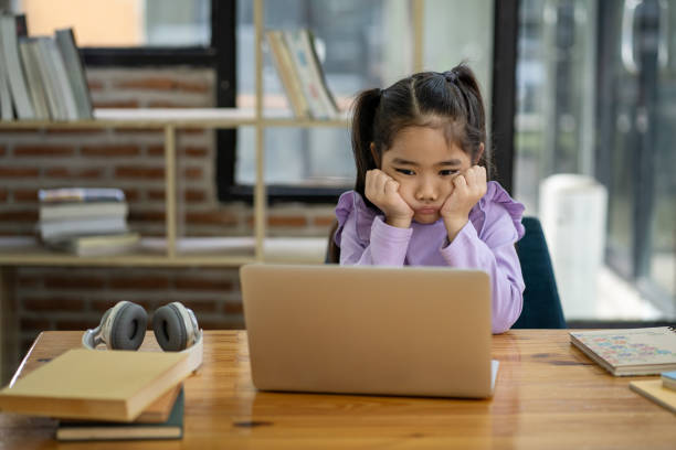 istock Young Asian girl doing homework online using laptop computer to improve her learning skills. 1911403407