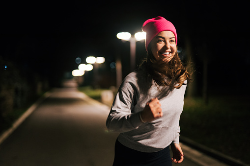 Sporty woman running  outdoor at night.