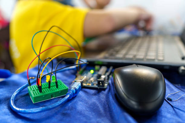 In a science project, a close-up view of a DIY robotic car on working desk background captures the essence of coding, technology, robotics, and science. This image represents the exciting intersection of these fields, showcasing innovation and the future of technology.