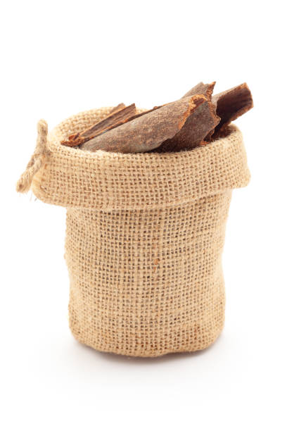 Close-up of Dry organic Cinnamon sticks (Cinnamomum verum) in a jute bag. Isolated over a white background.