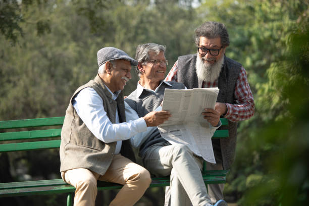 istock Senior friends reading newspaper in park 1911455165